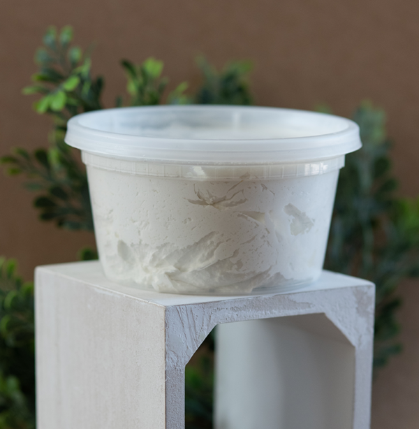 Tub of shea butter on a white pedestal.